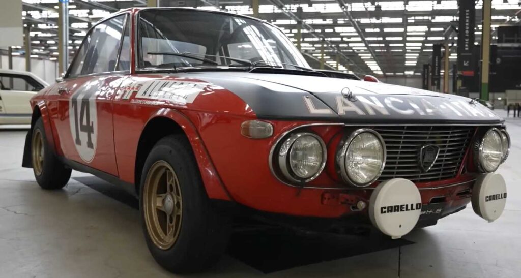 červená Lancia Fulvia s čiernym kufrom