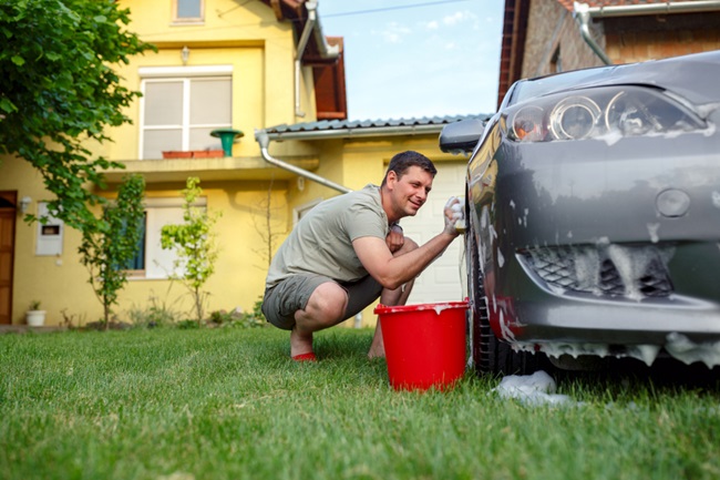 Muž umývajúci auto na svojom dvore